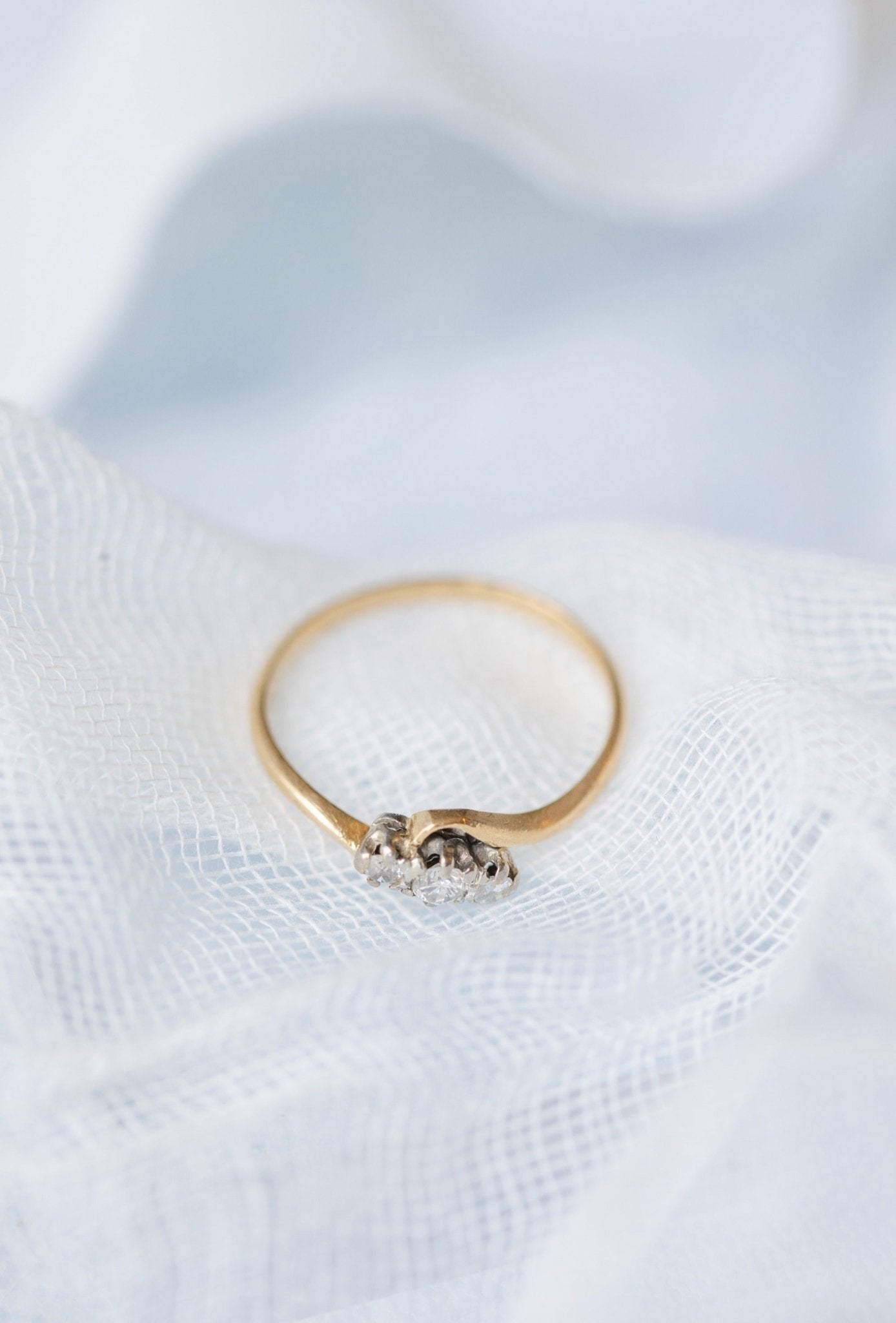 Close up of an 18ct Gold and Platinum Diamond Vintage Engagement Ring sitting on a white fabric. 