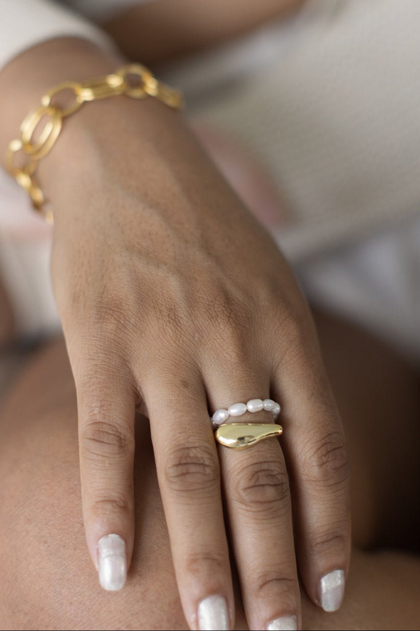 A woman's hand wearing the Everyday Freshwater Pearl Ring and the Essence Figure Gold-Filled Ring. Gold Filled jewelry Canada.