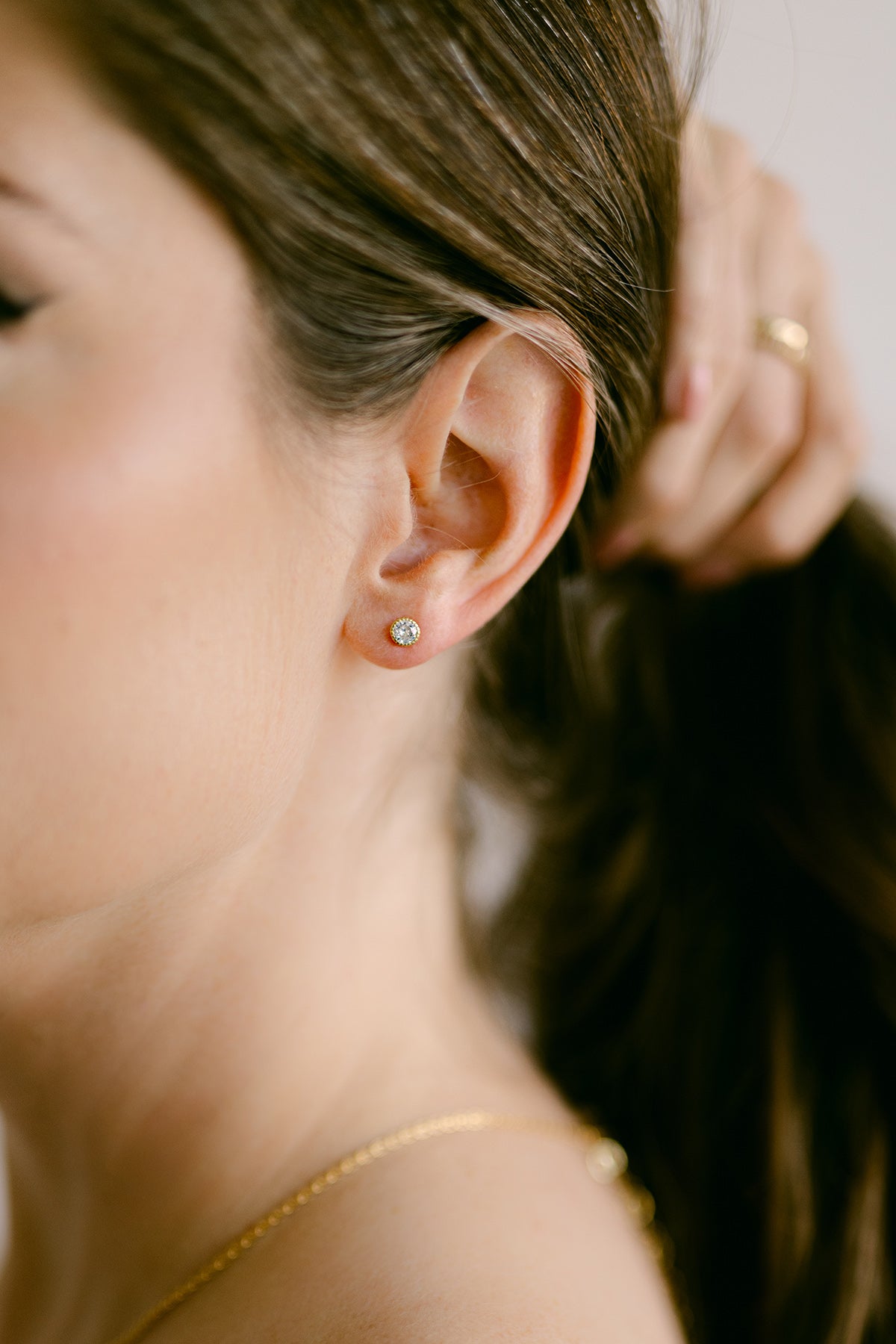 Close-up of woman holding hair back to show a large crystal stud earring. Everyday jewelry. Statement Earrings. Woman-owned business. Canadian jewelry business.