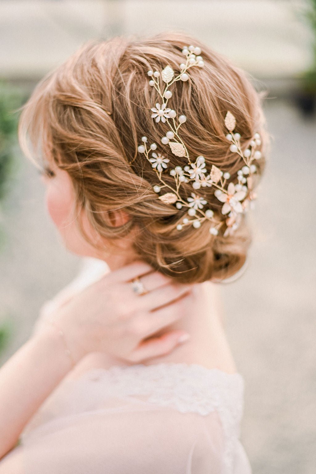 Gold Evette Floral Hairpiece with Freshwater Pearls is hugging the back of a bride's hair-do. Bridal Hair Accessories. Bridal Accessories. Canadian Bridal Accessories. Handmade Canadian Accessories. Canadian handmade Accessories. Canadian weddings. Wedding Canada. Organic pearl accessories. Pearl Bridal Hair Accessories. Pearl Bridal Accessories.