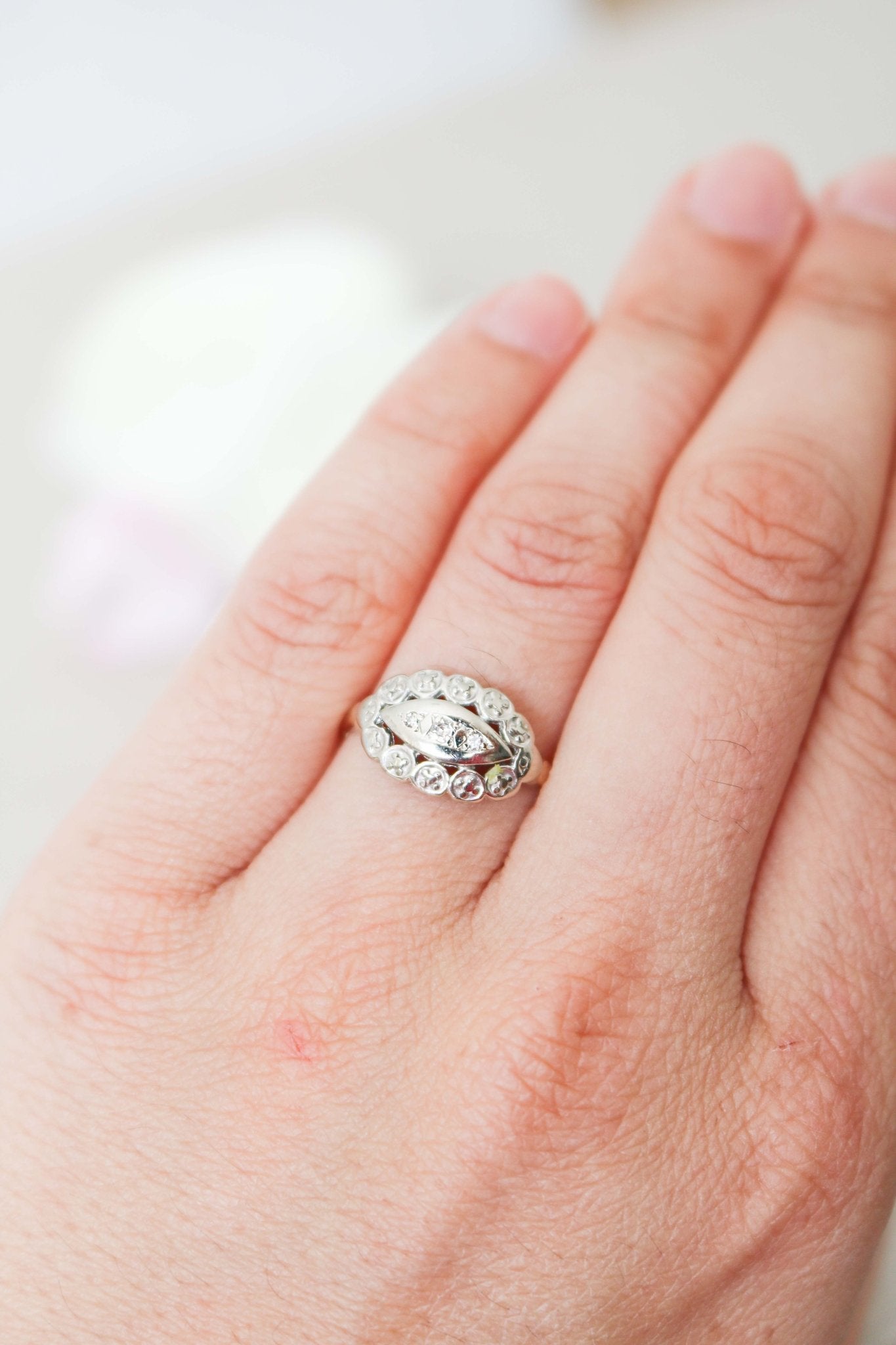 A 14ct Gold Art Deco style multi-diamond Vintage Engagement Ring circa 1920s on a ring finger. 