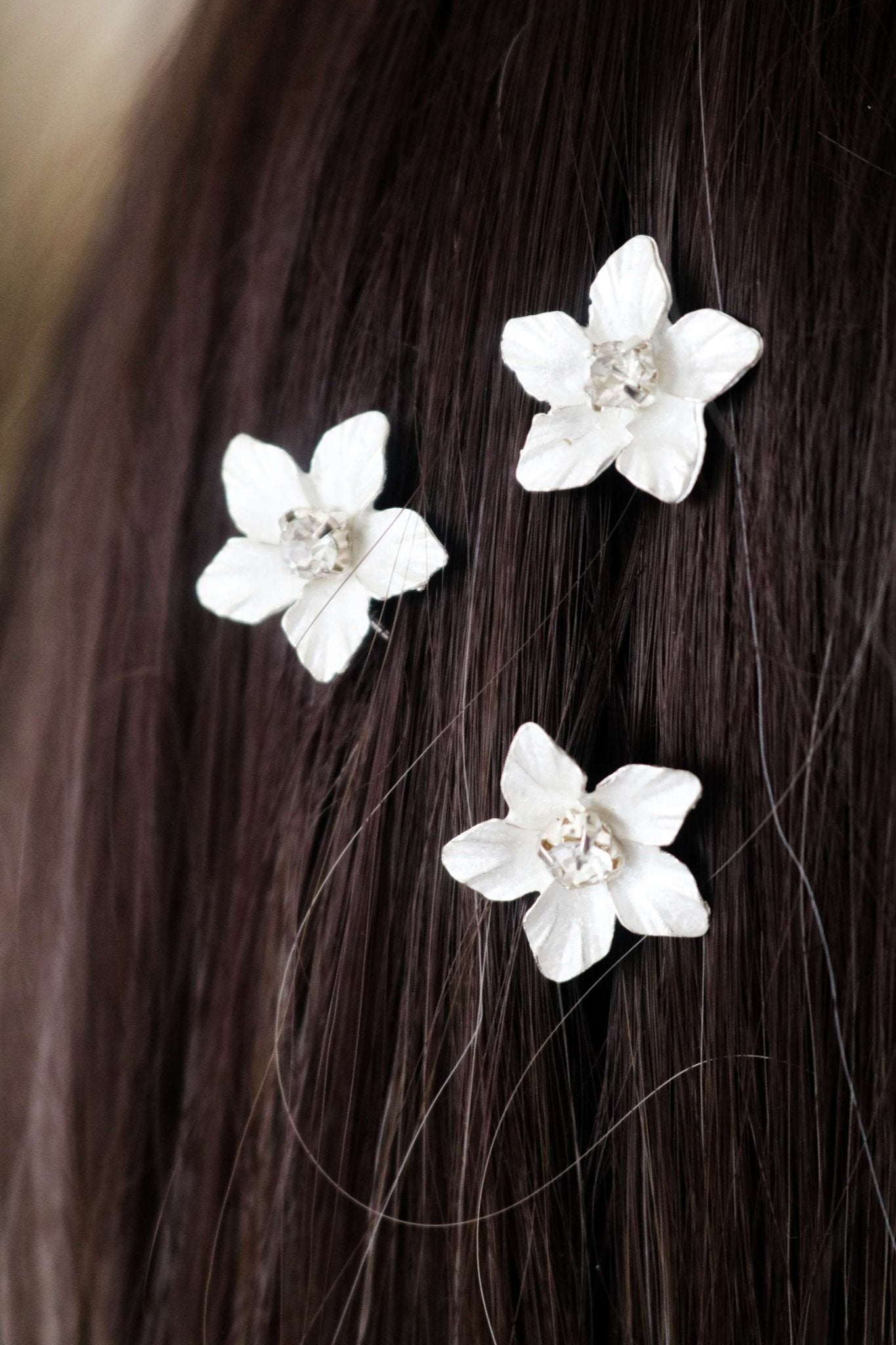 Three single silver Feya Crystal Flower Bridal Hairpins set in straight dark hair. 