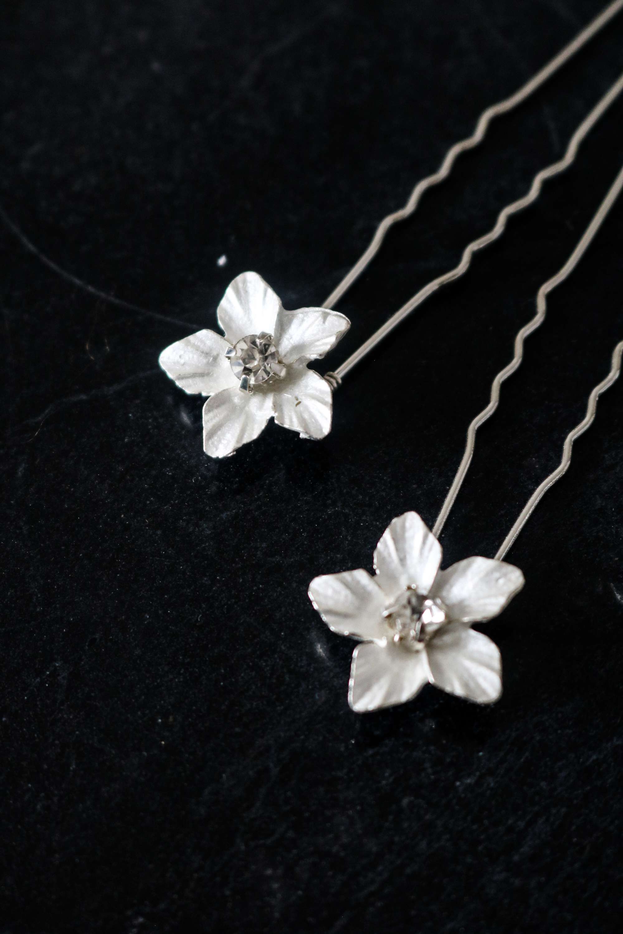 Two Silver Feya Crystal Flower Hairpins on a dark background.