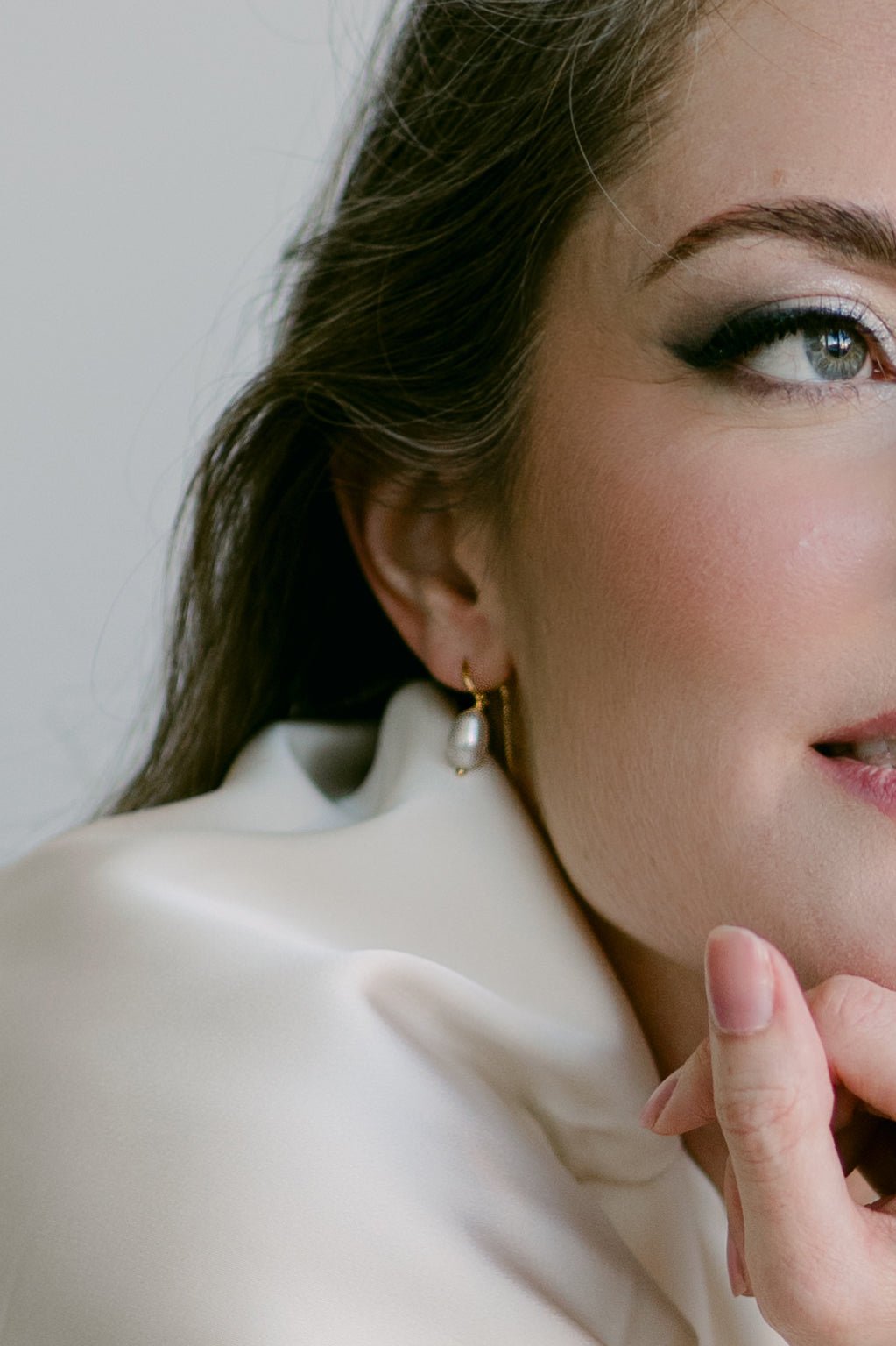 Close-up of a woman wearing 14k gold-filled freshwater pearl threader earrings. Pearl Bridal Accessories. Pearl jewelry Canada. Canadian jewelry business.