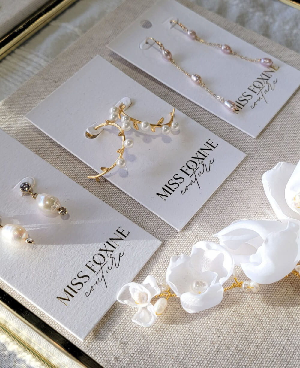 A display of gold-filled freshwater pearl bridal earrings and floral bridal hair comb.