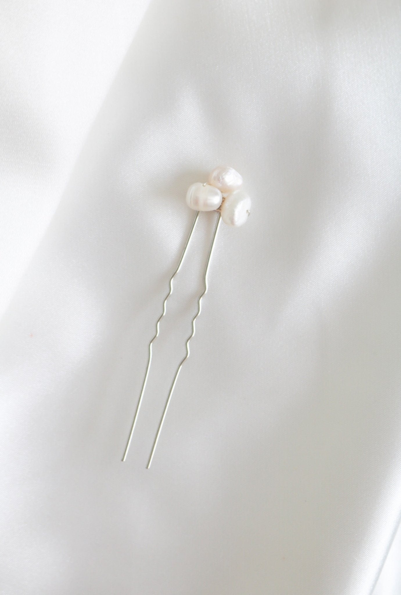 A single silver bridal hairpin with organic freshwater pearls on white background.