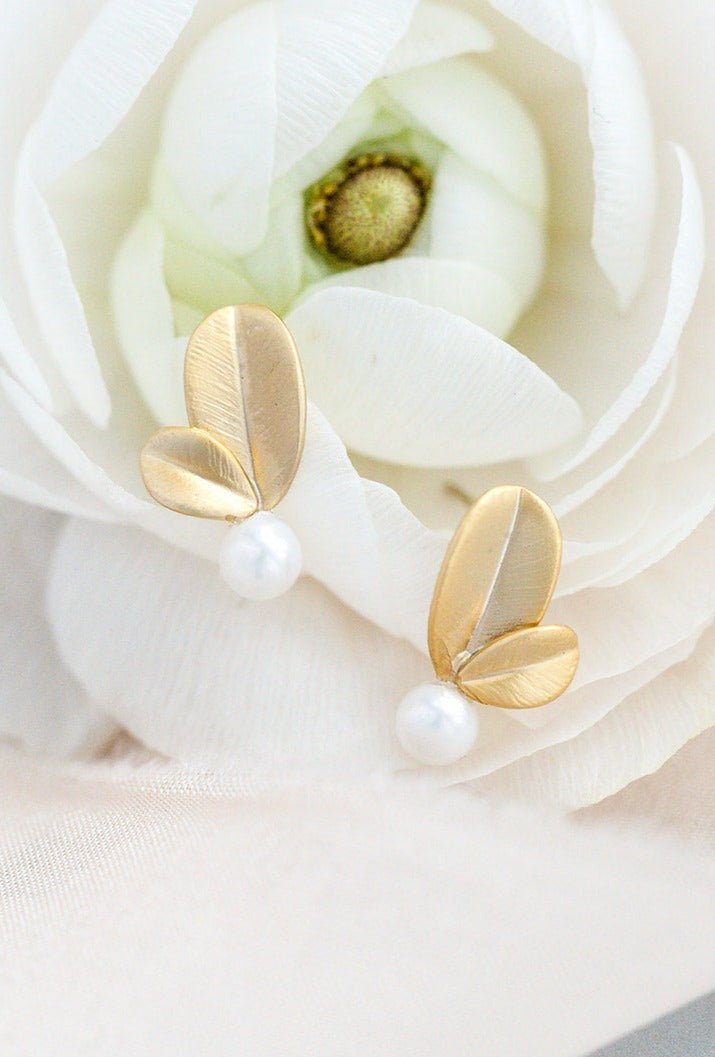 A pair of gold-filled leaf studs with sterling silver posts and freshwater pearls in white rose. Handmade bridal  earrings & Pearl earrings Canada.