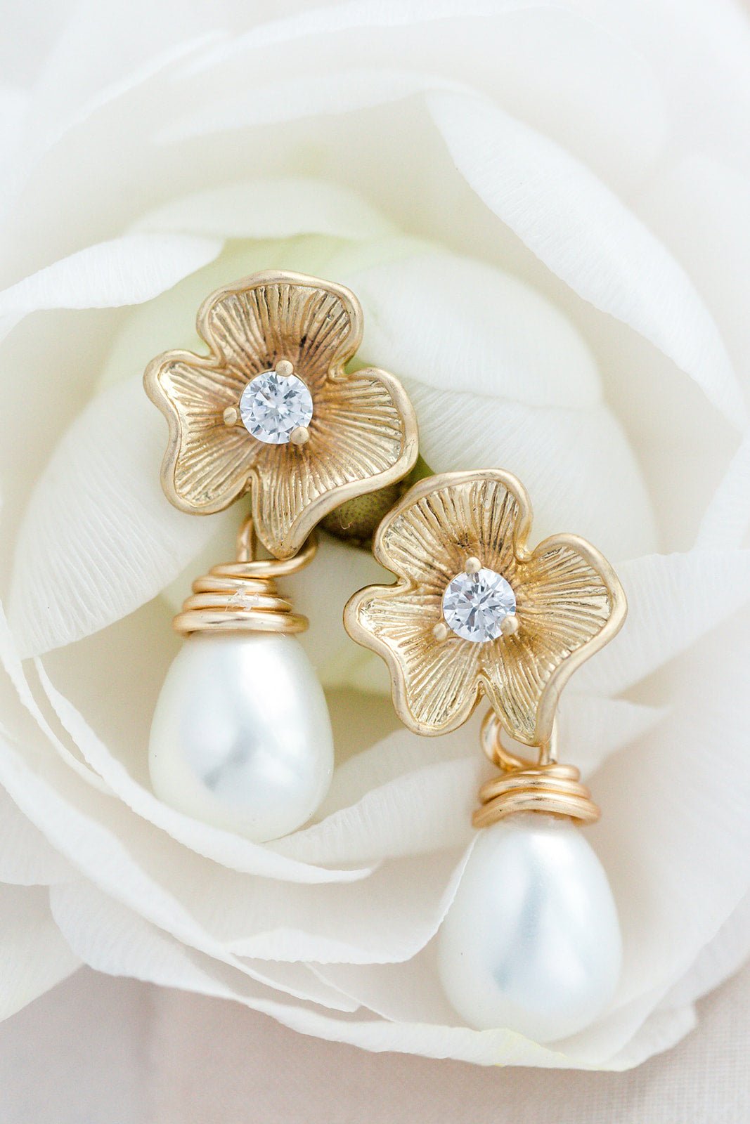 A pair of gold-filled flower earrings with freshwater pearl drops and crystal centers on a white rose. Bridal jewelry Canada. Pearl jewelry Canada. Pearl Bridal jewelry Canada. Gold-filled jewelry Canada. Organic pearl jewelry. Handmade Canadian jewelry.