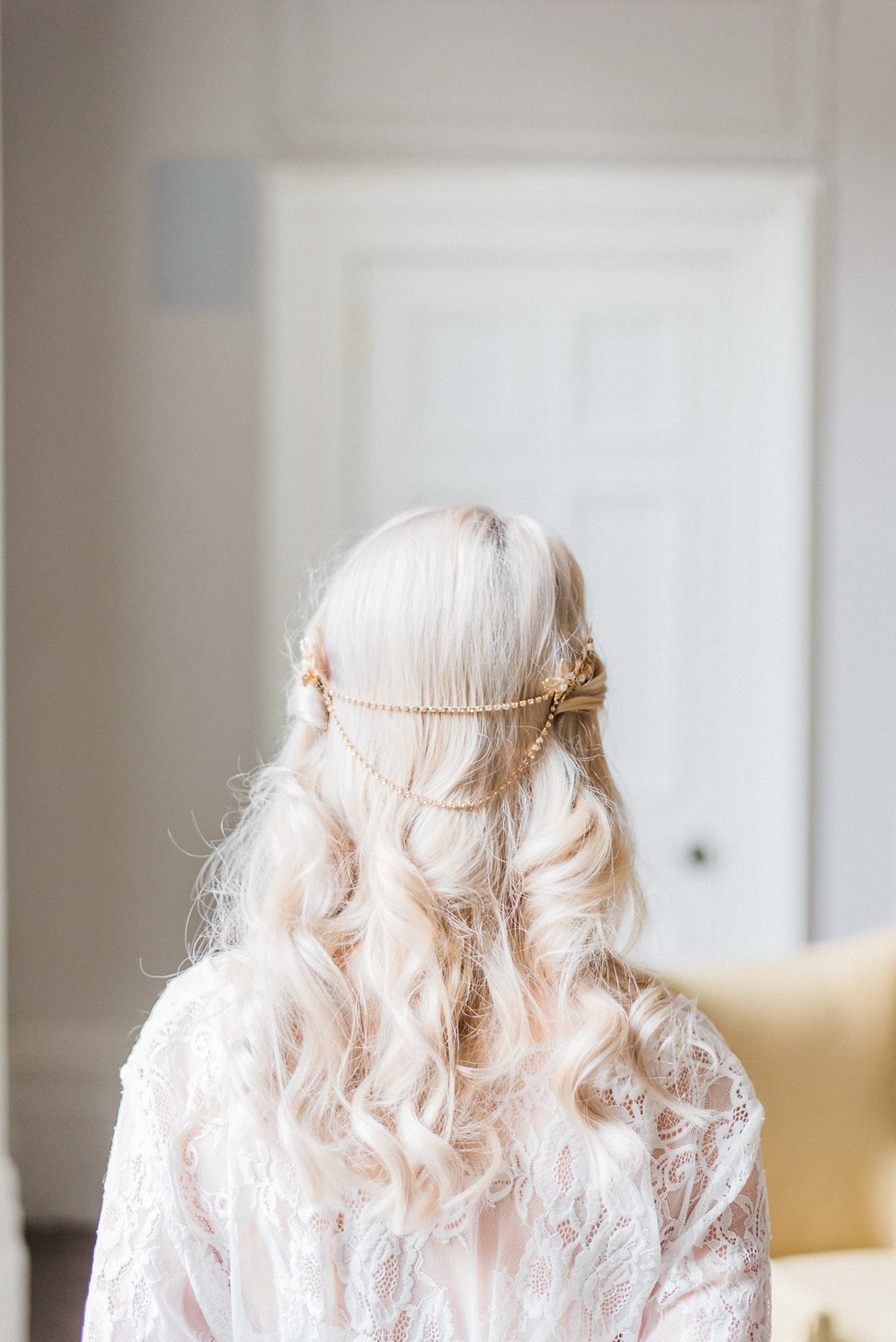 A back view of a bride wearing the Gold Livia Crystal and Freshwater Pearl Leaf Hairpiece.