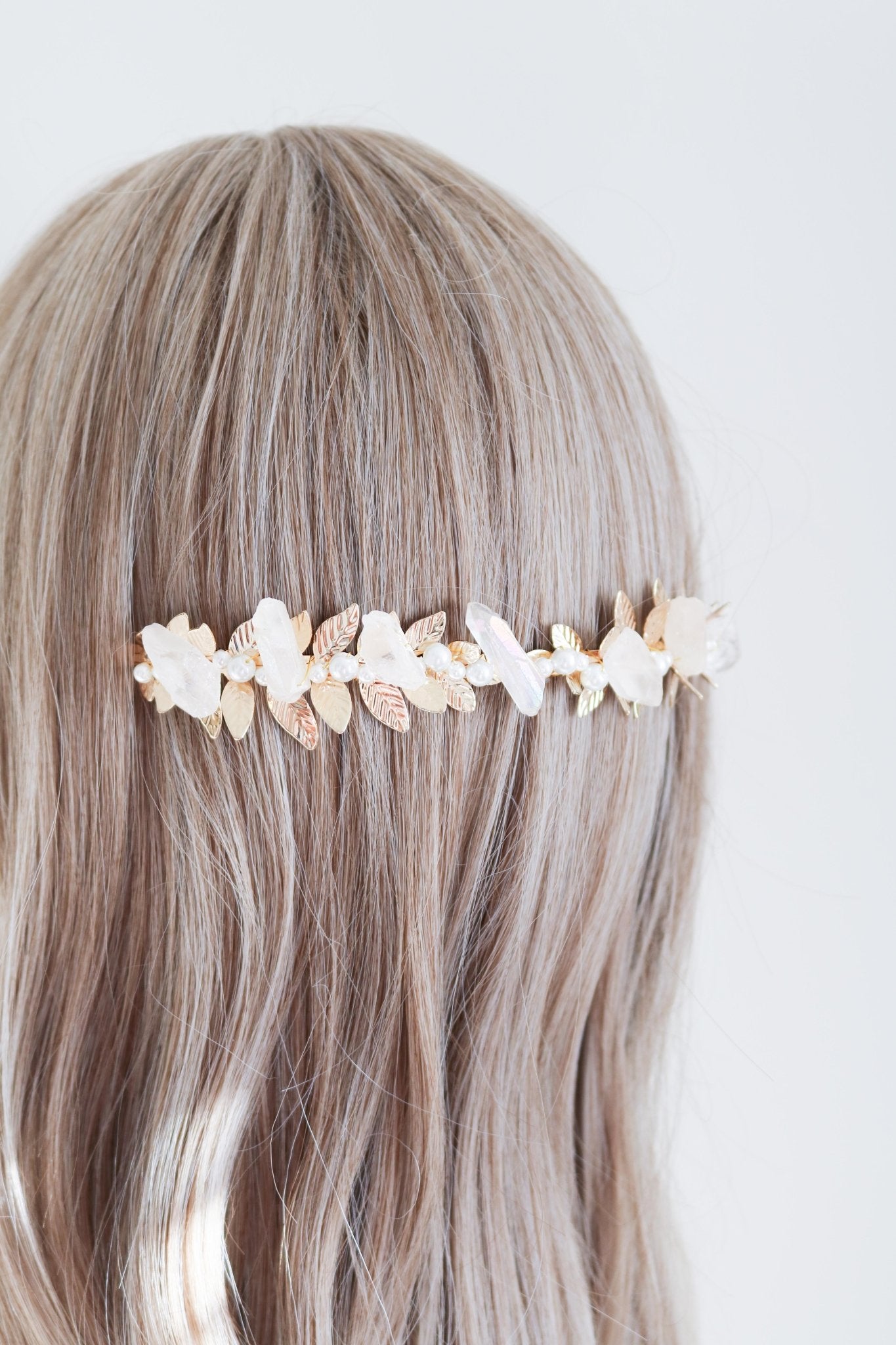 A gold laurel pearl and quartz bridal headband in the back of long blonde hair. Bridal hair accessories & Pearl bridal accessories handmade by BIPOC bridal jewelry designer