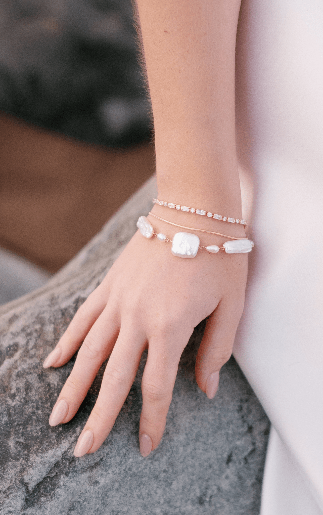 Elegant stack of gold-filled bracelets. Crystal tennis bracelet, dainty plain chain bracelet, and statement freshwater pearl bracelet. 