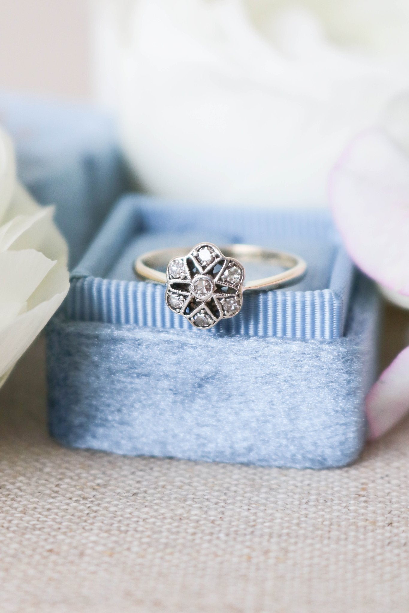 Mae Art Deco Diamond Vintage Engagement Ring in 18ct Yellow Gold and Platinum from the 1920s sitting atop a blue ring box.