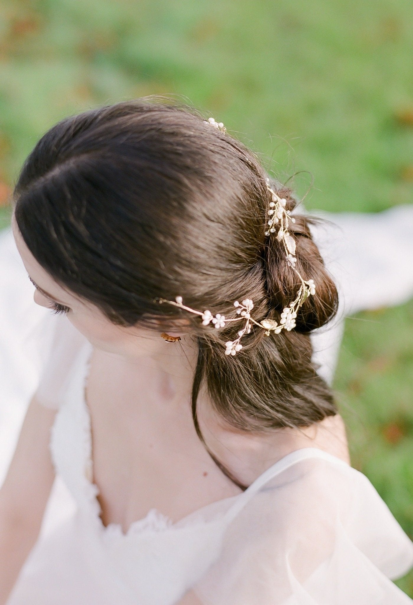 The top view of a bride and her partial up-do; adorned with a gold wired leafy bridal hairvine with freshwater pearls and crystals.