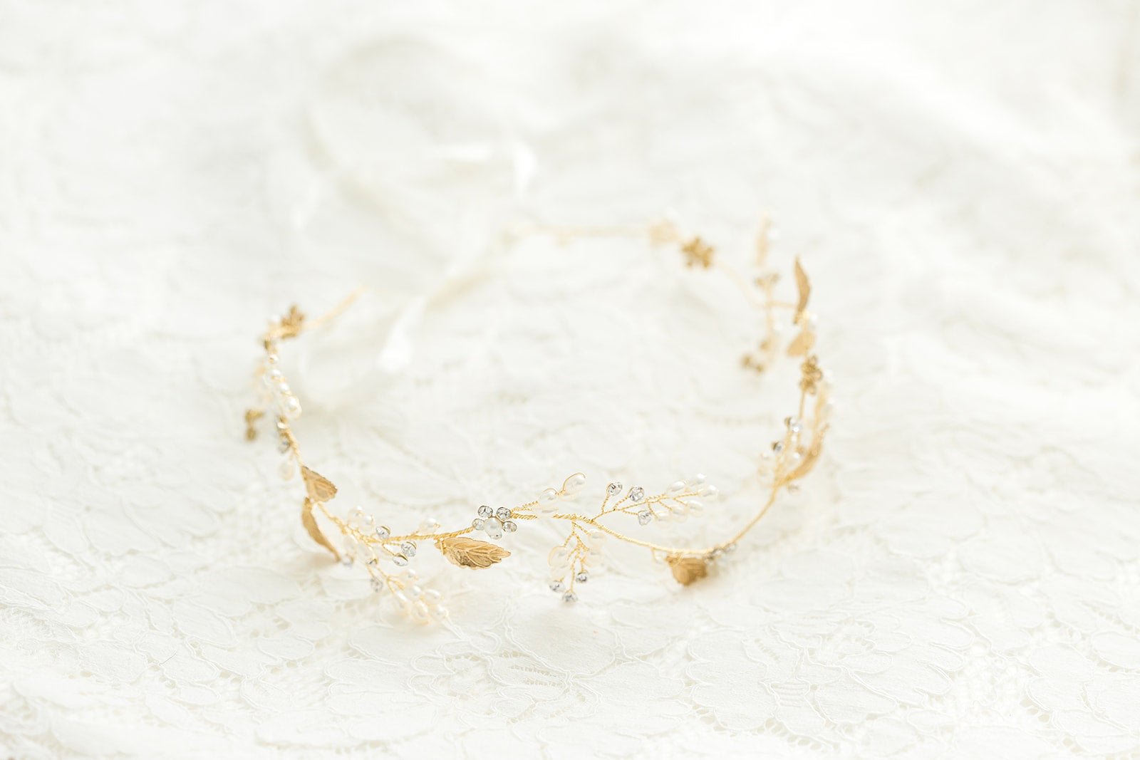 The Gold Meadow Freshwater Pearl and Crystal Leaf Bridal Hairvine on a white background. 