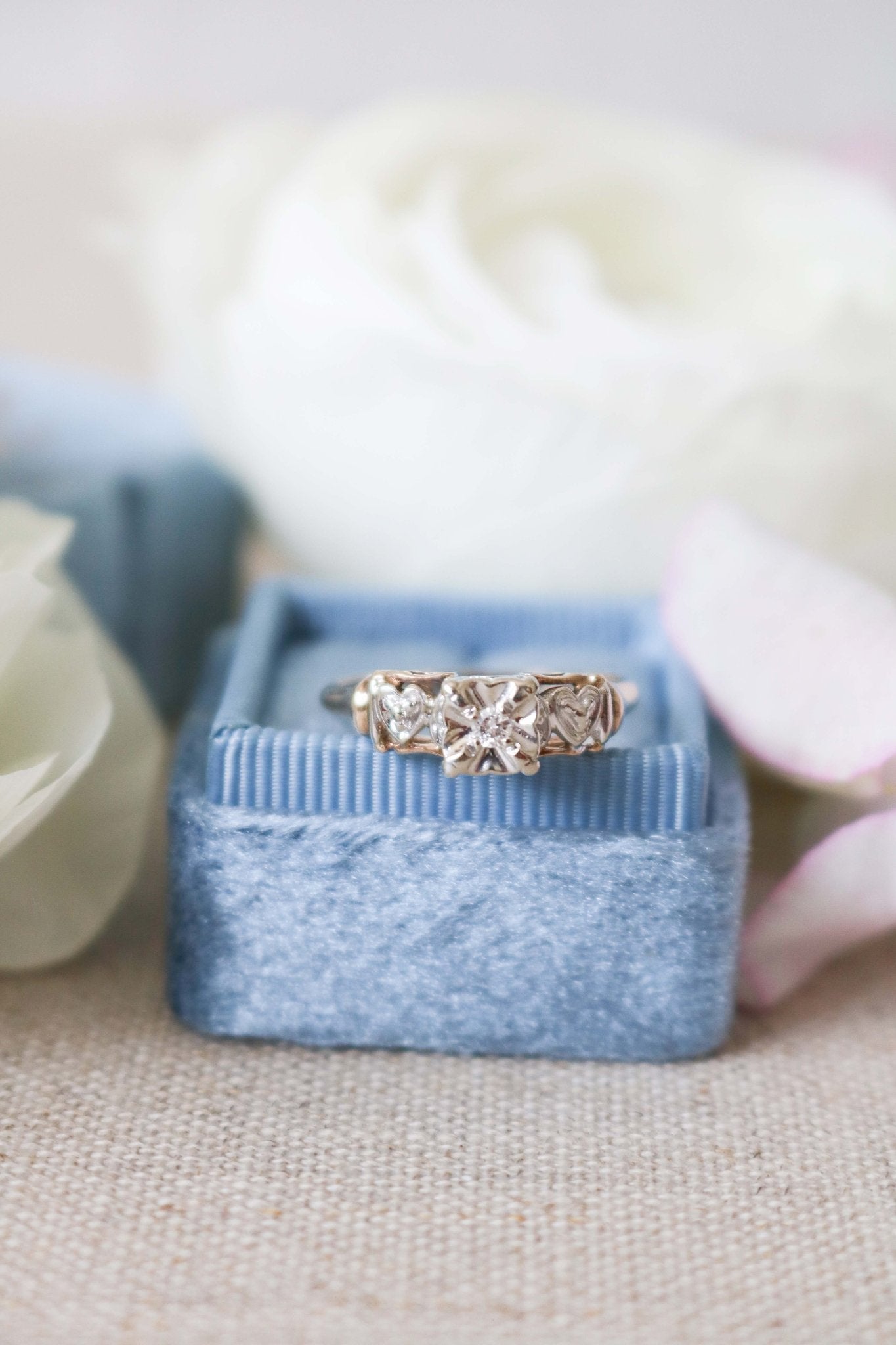 Front view of Yellow and White Gold Vintage Engagement Ring with Diamond Hearts on top of ring box. 