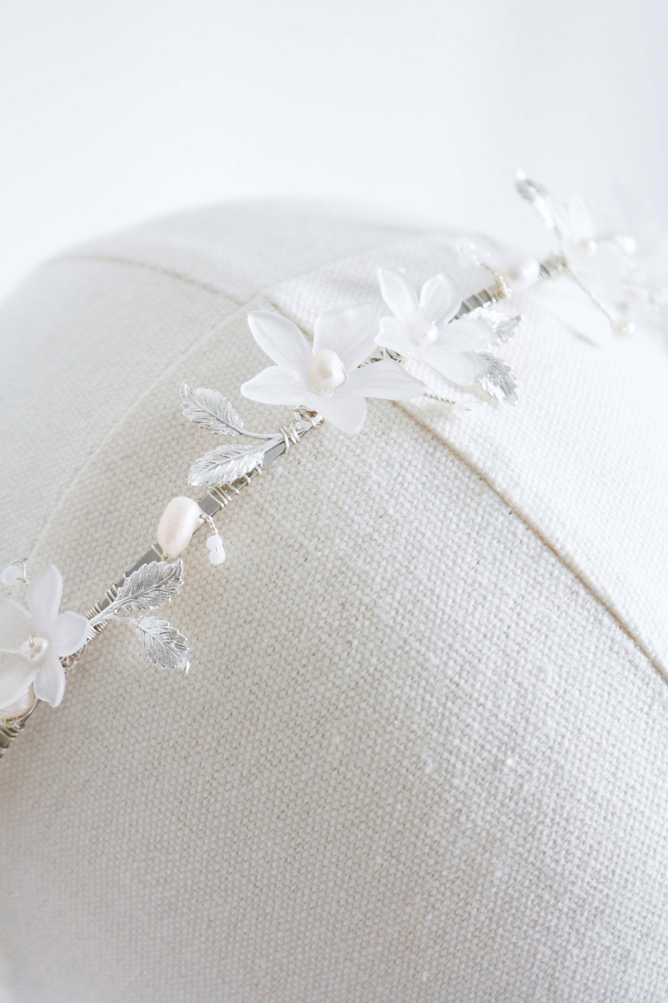 An extreme close up of the Melody Fresh Water Pearl and Floral Bridal Headband on a head bust. Bridal Hair Accessories. Bridal Accessories. Canadian Bridal Accessories. Handmade Canadian Accessories. Canadian handmade Accessories. Organic pearl accessories. Canadian weddings. Wedding Canada. 