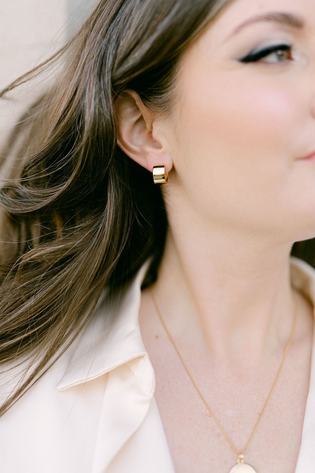 A woman wearing the modern wide gold-filled huggies. Gold-filled jewelry Canada. Canadian jewelry maker.