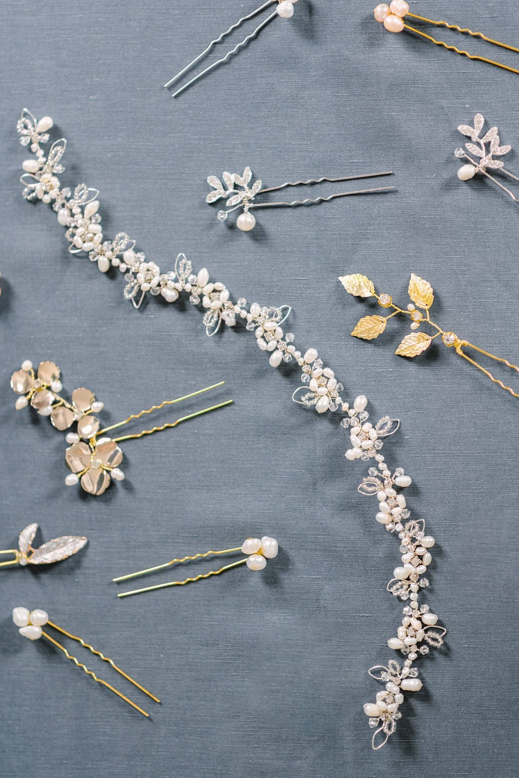 A gold crystal and freshwater pearl bridal hairvine surrounded by hairpins.