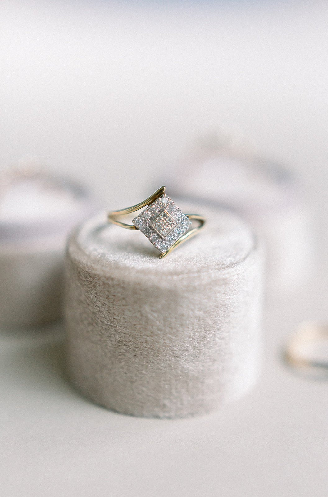 The Novah Vintage Diamond Ring in 10k Yellow & White Gold c.1940's sitting atop a rounded grey ring box.