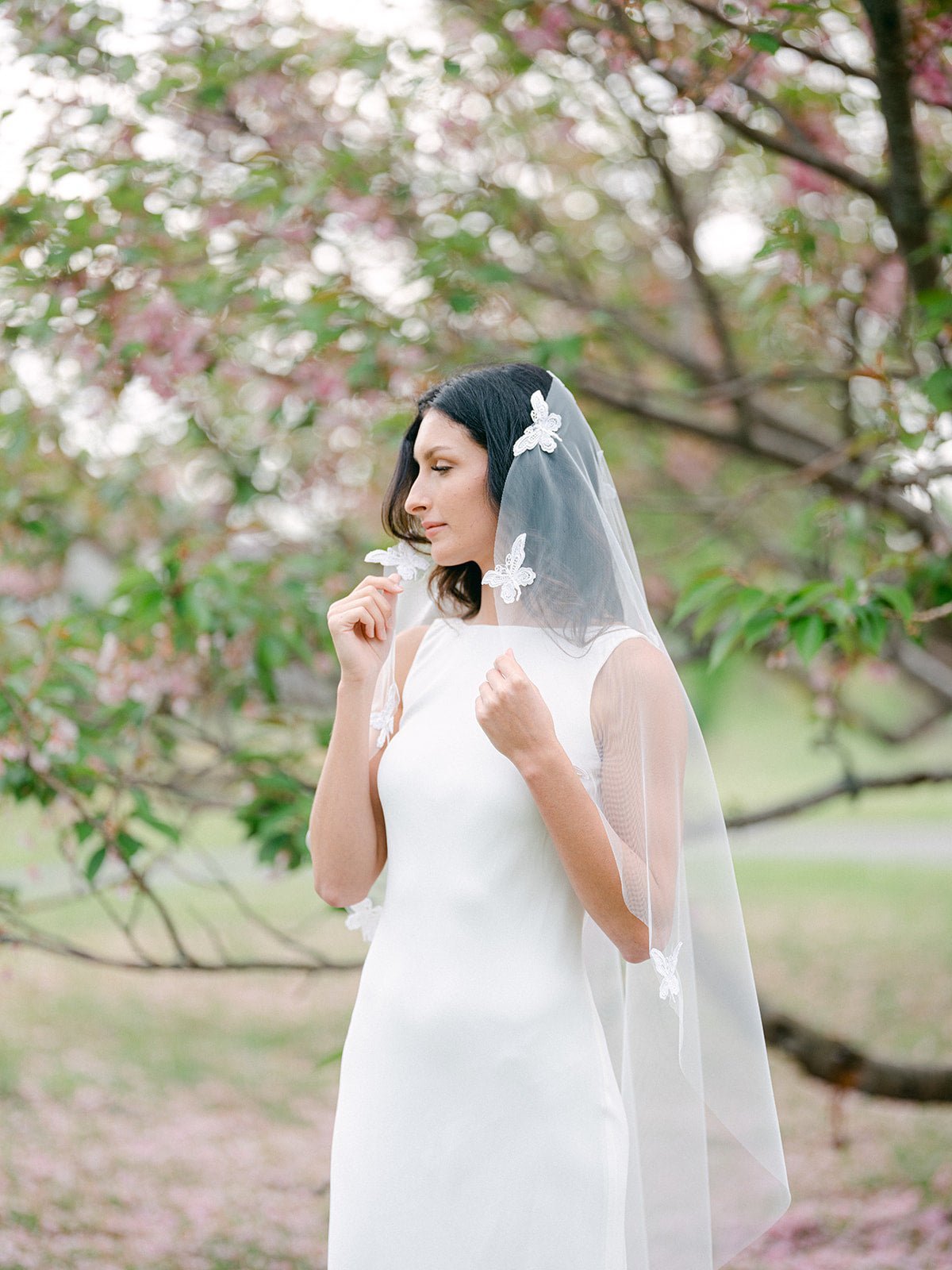 Thoughtful bride holds Papillion Lace Butterfly Wedding Veil. Canadian weddings. Wedding Canada. Wedding veils Canada. Bridal Hair Accessories. Bridal Accessories. Canadian Bridal Accessories. Handmade Canadian Accessories. Canadian handmade Accessories. Canadian designer. Canadian artist.