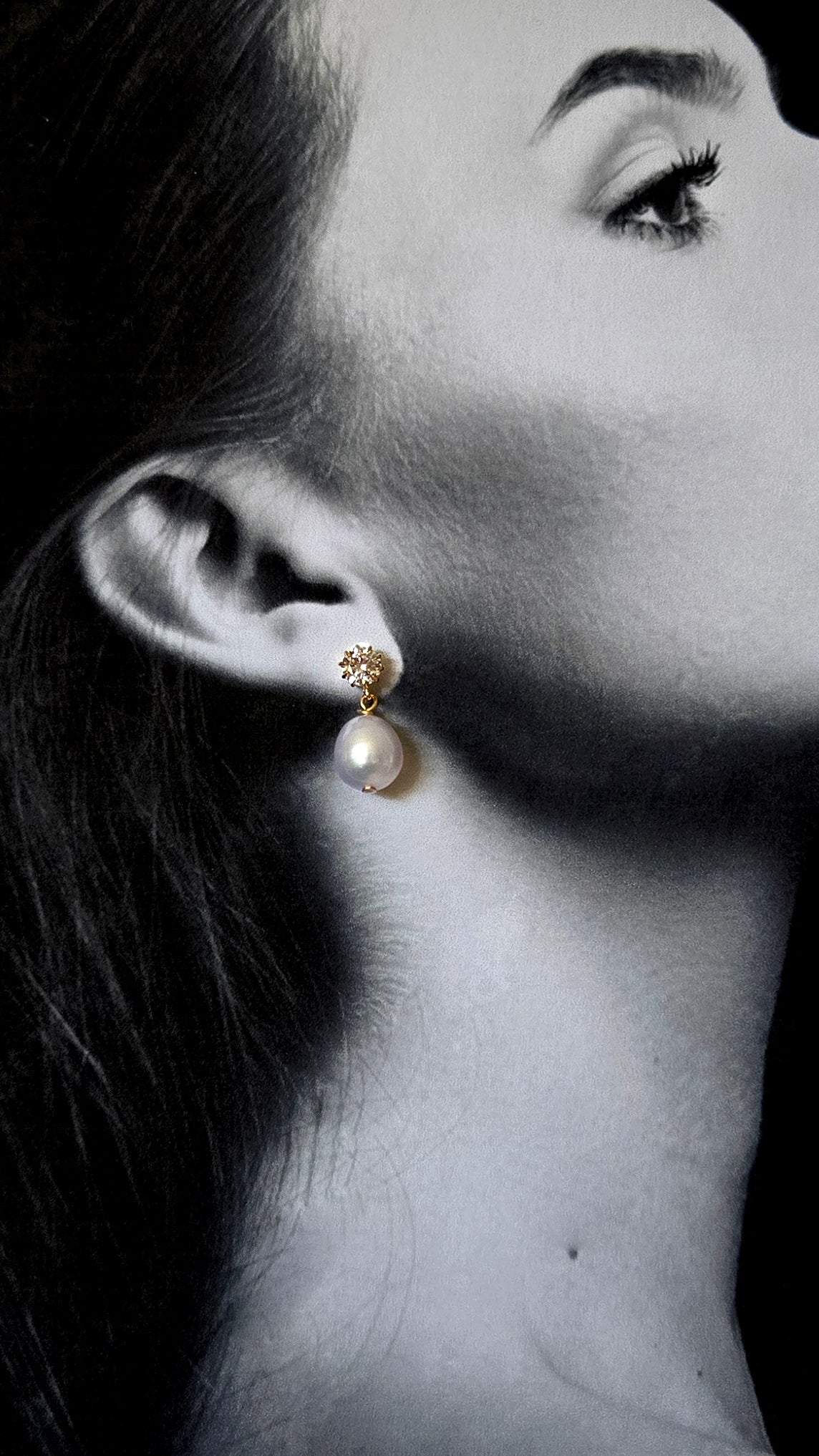 Close-up of a black and white photo of a woman wearing gold pearl stud earrings with crystals and freshwater pearls. Pearl bridesmaid earrings, Canadian bridal jewelry, & Bridesmaid jewelry handmade by BIPOC jewelry designer