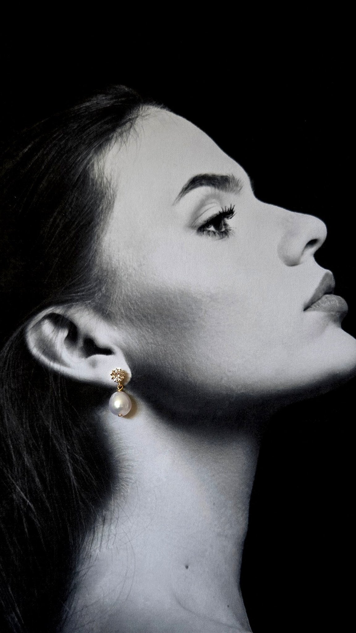 Black and white profile of a woman wearing gold pearl earrings with crystals against a black background. gold pearl earrings, bridesmaid earrings, & pearl bridal earrings handmade by BIPOC jewelry designer