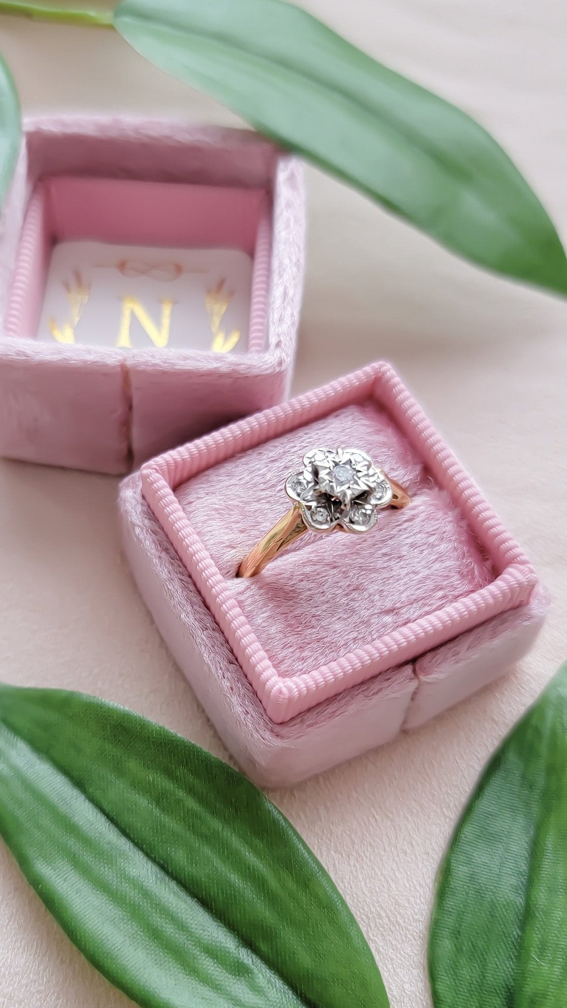 A close up of the Posy 18ct Yellow and White Gold Diamond Flower Vintage Engagement Ring in pink ring box. 