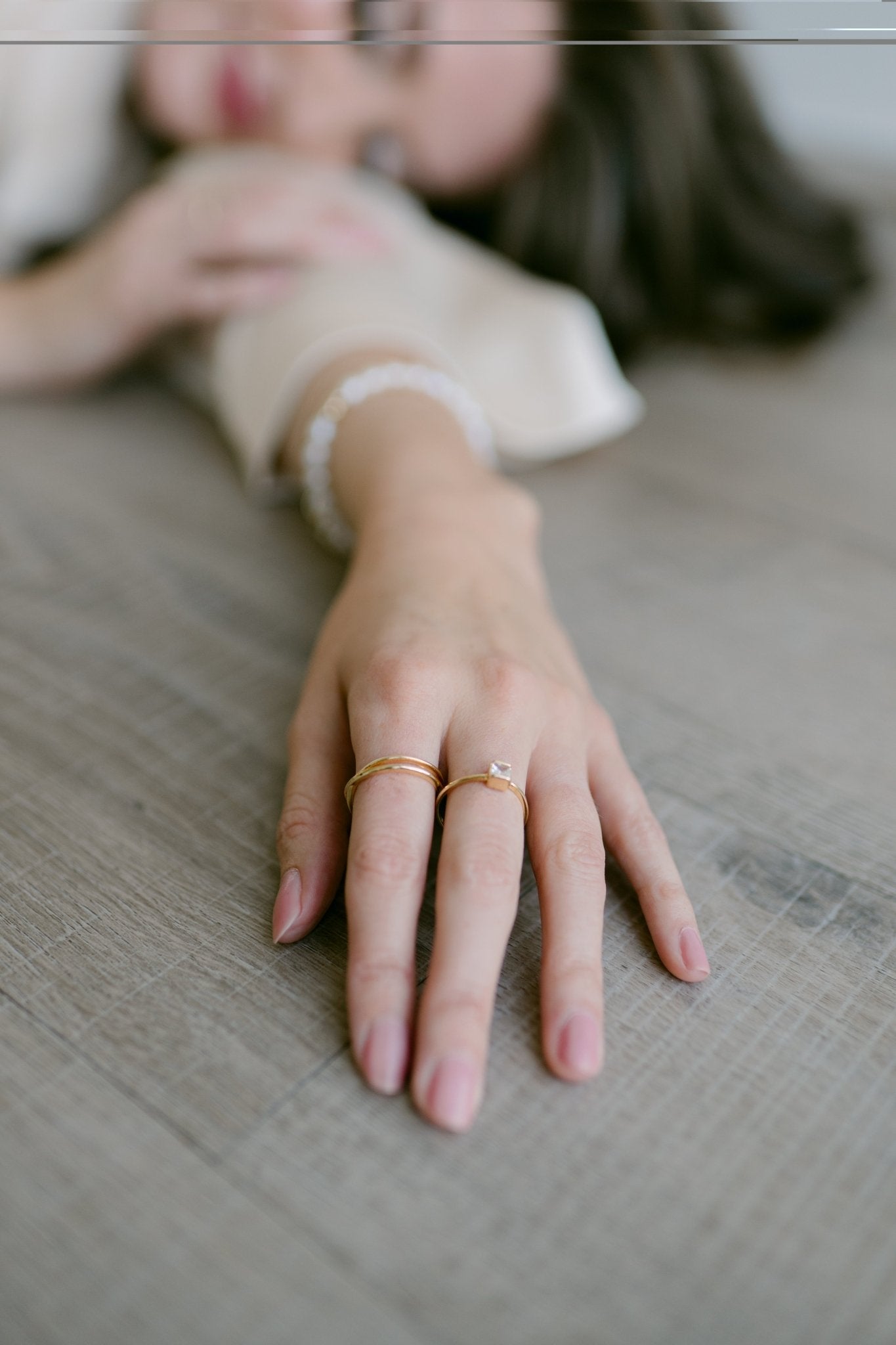 A woman's outstretched arm wearing 2 gold-filled rings. Canadian jewelry maker. Woman-owned Canadian jewelry brand. 
