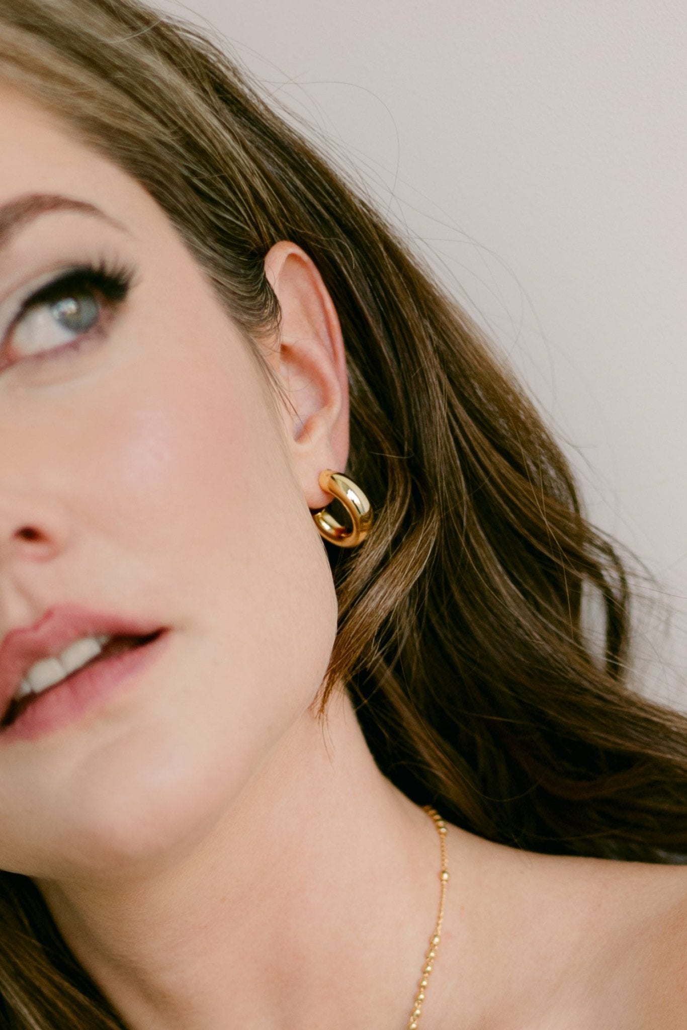 A woman wearing a puffy gold-filled hoop earring. Statement jewelry. Canadian designer. Gold-filled Canadian jewelry. 