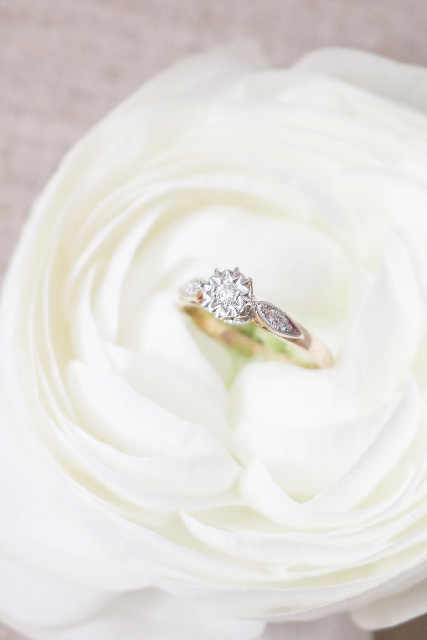 The Serena  Diamond Vintage Engagement Ring in 9ct Yellow and White Gold, c1930s nestled in a white rose. 