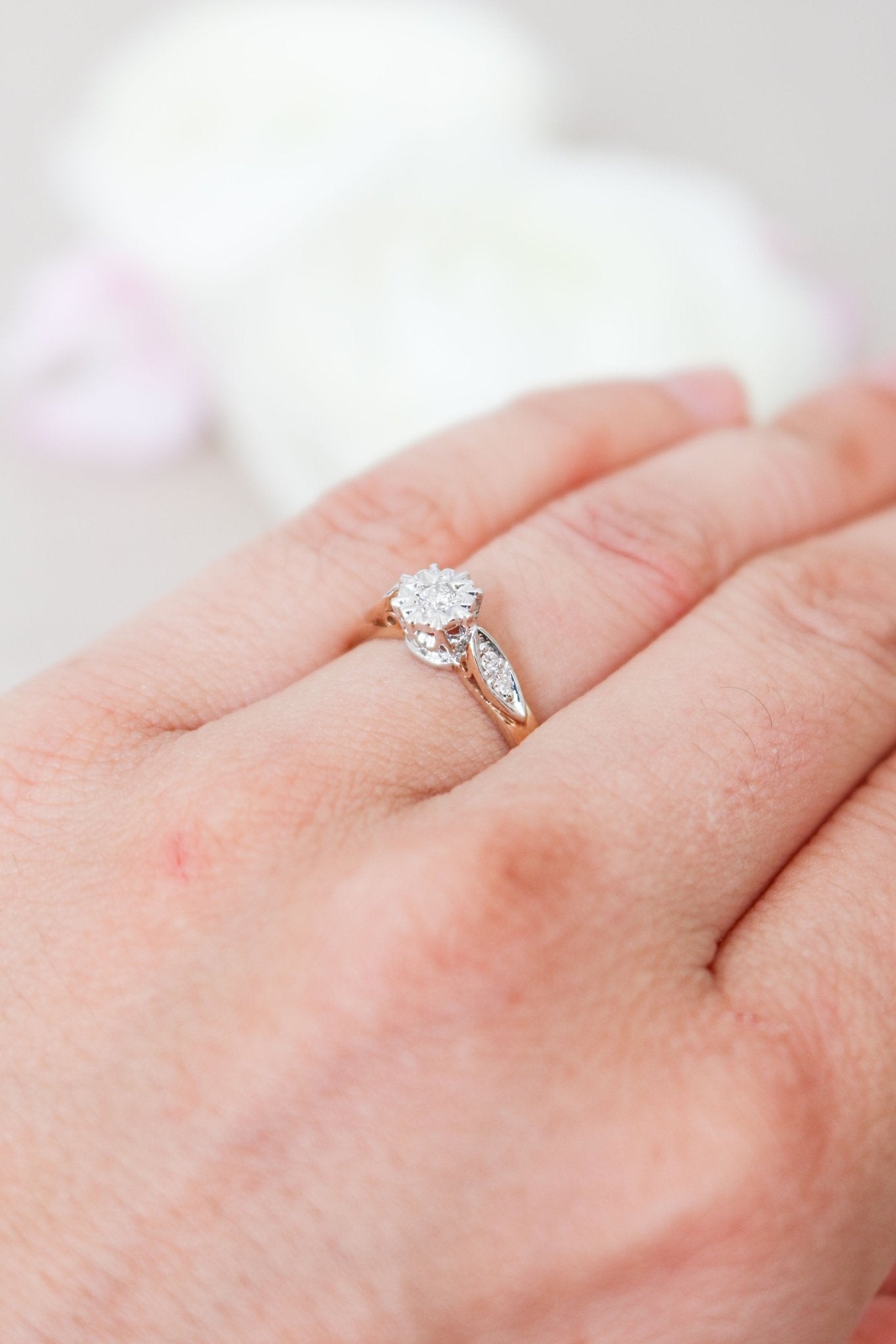 Close up side view of a Serena Diamond Vintage Engagement Ring in 9ct Yellow and White Gold on a ring finger. 