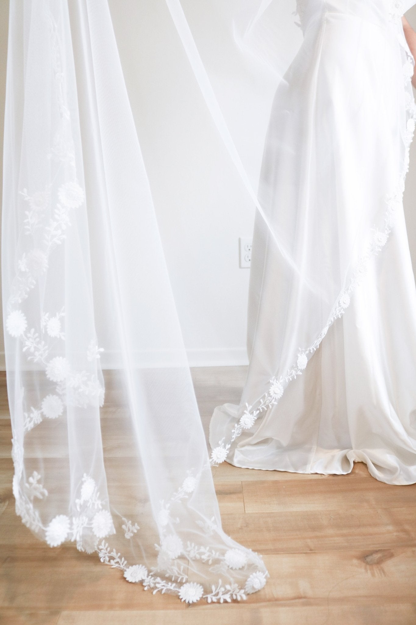 Wedding Veil with floral and vine lace trim being held up and displayed. 