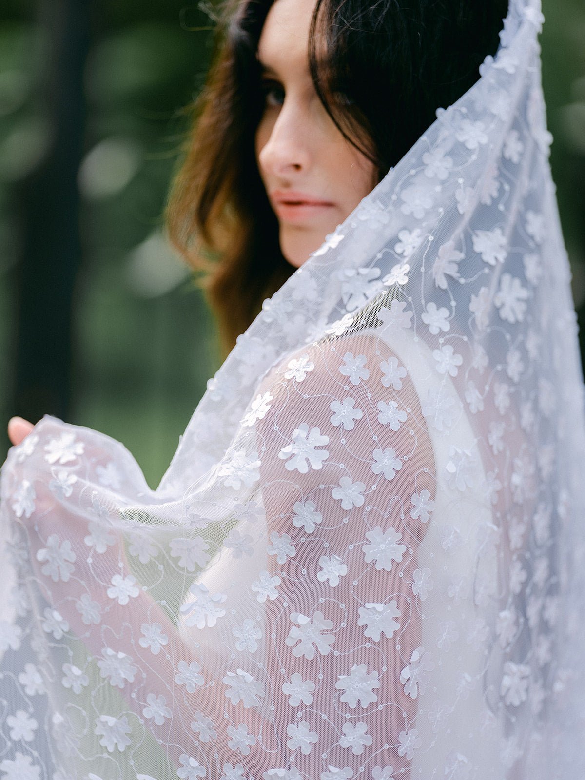 A bride wraps herself in the Sonnet Floral Wedding Veil.