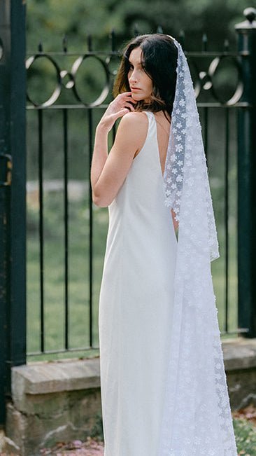 Bride looks over her shoulder as her Sonnet lacey floral wedding veil runs down her back to the ground. Canadian weddings. Wedding Canada. Wedding veils Canada. Bridal Hair Accessories. Bridal Accessories. Canadian Bridal Accessories. Handmade Canadian Accessories. Canadian handmade Accessories. Canadian designer. Canadian artist.