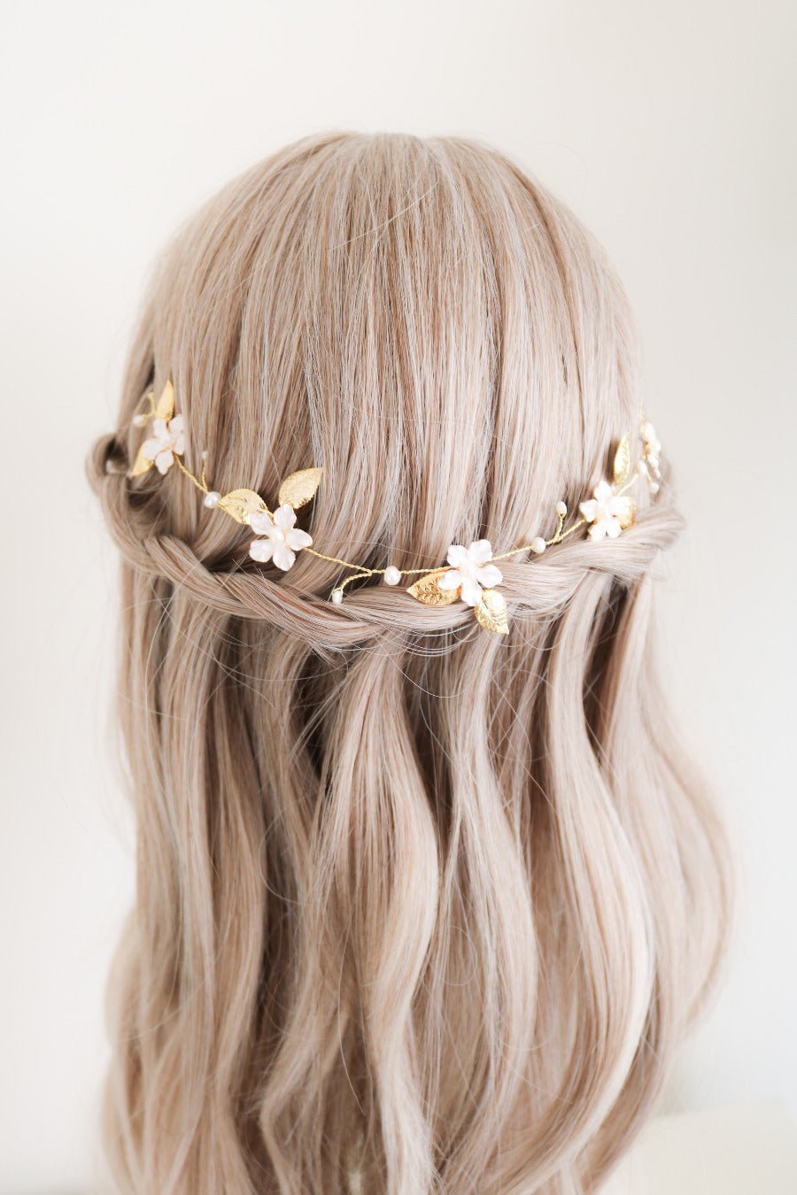 The dainty Spring Bridal Hairvine with Fresh Water Pearls in Gold displayed on top of a loose horizontal braid. 