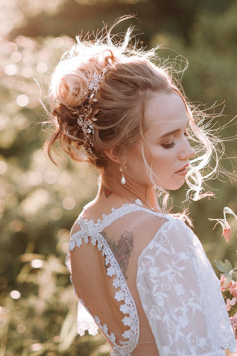 Blonde bride in the sun wearing a white lace wedding dress with gold floral hairpiece with enamel and Swarovski crystals with outdoor background. Canadian bridal accessories, bridal hair accessories, & handmade bridal accessories Canada