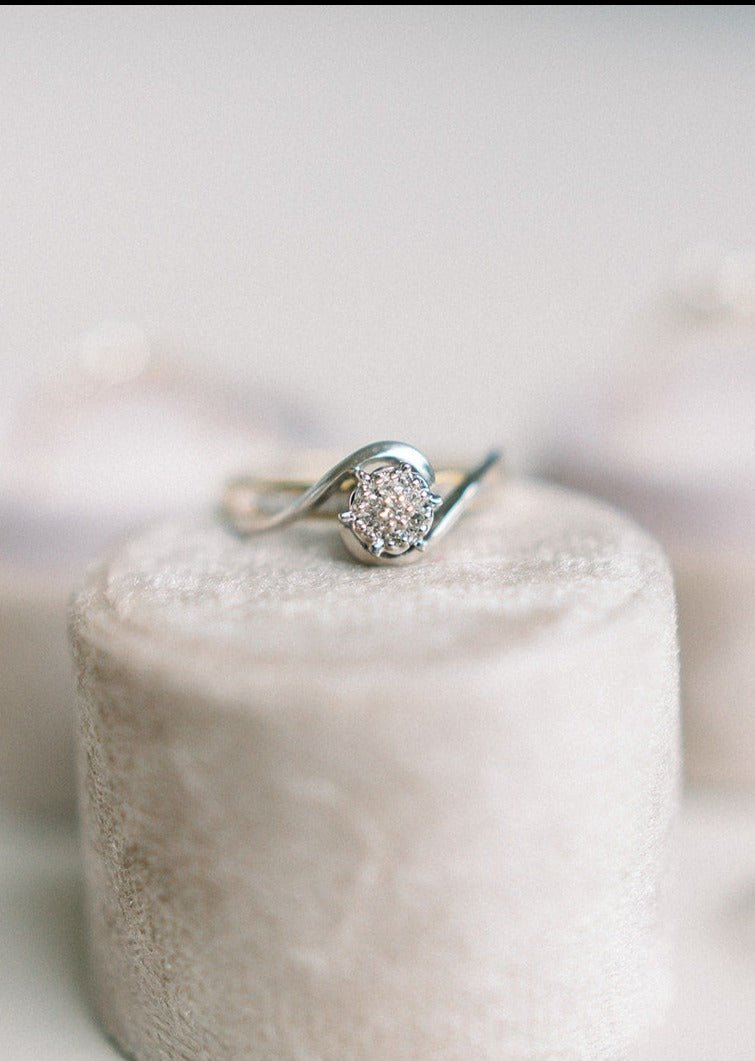 The Swan Diamond Vintage Engagement Ring in 10k Yellow & White Gold c.1940s sitting on top of a round beige ring box.