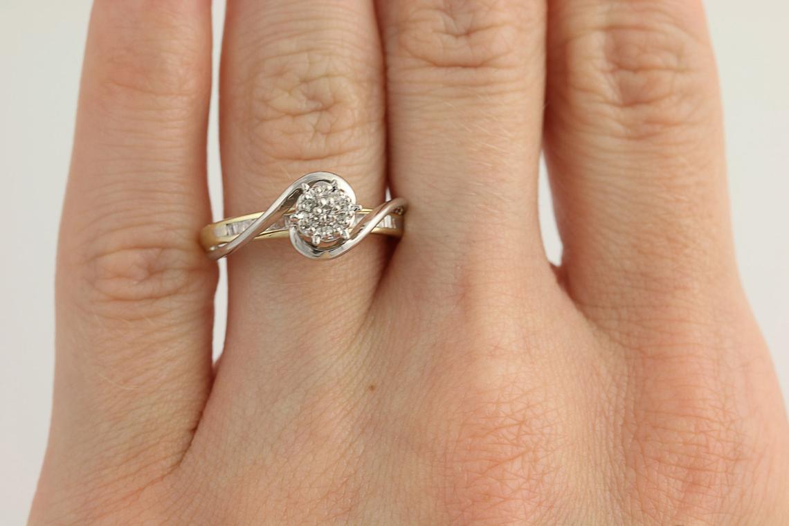 The Swan Diamond Vintage Engagement Ring in 10k Yellow & White Gold on a ring finger. 