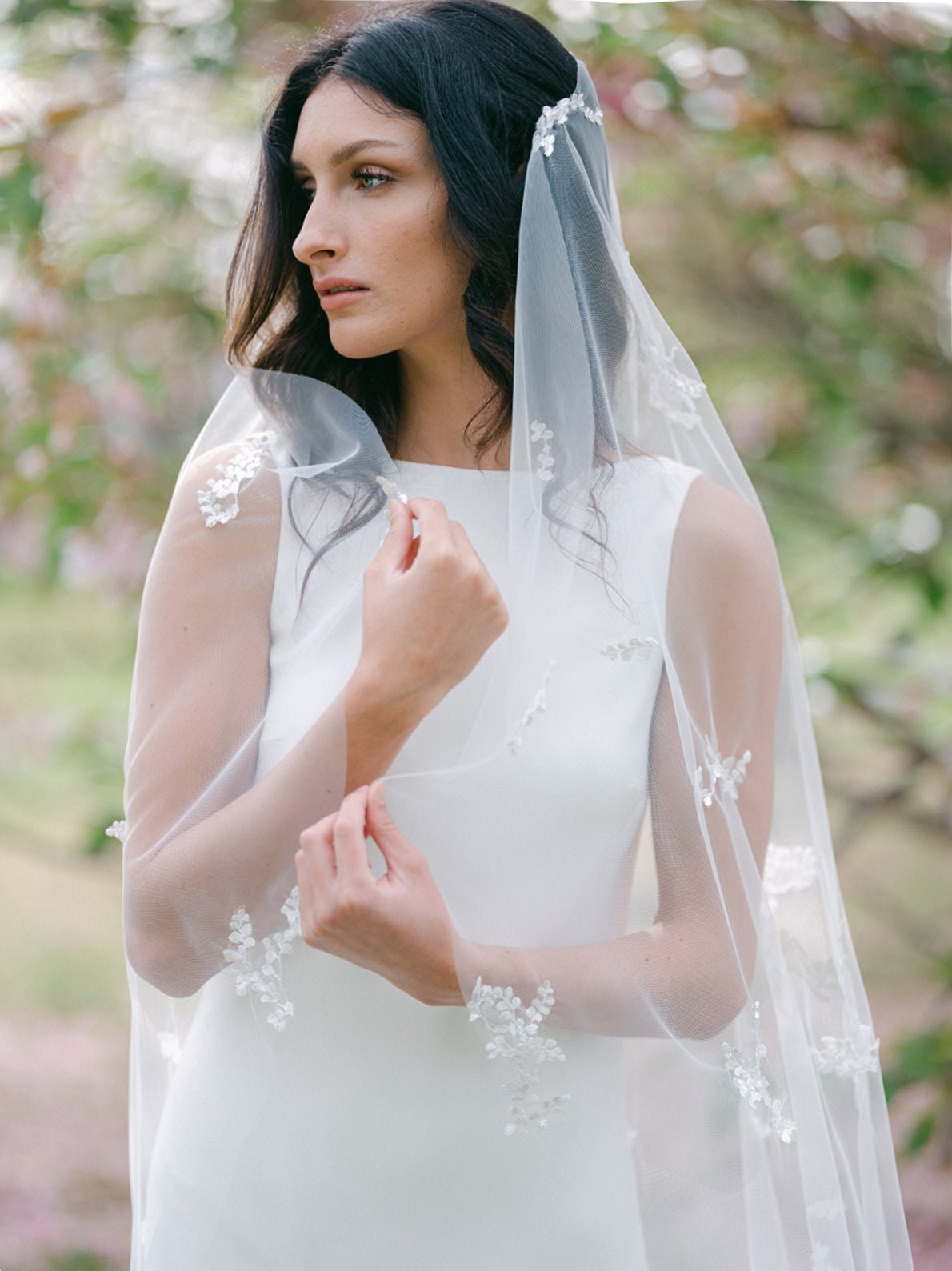 A bride drapes herself in her Wisteria Lace Leaf Wedding Veil.